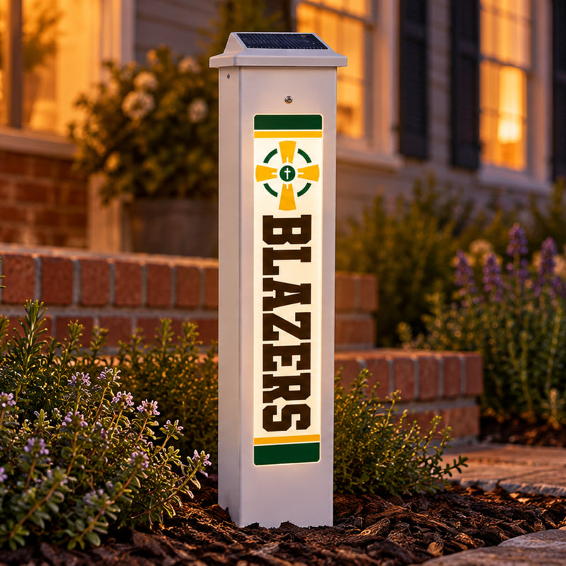 Beckman Catholic Blazers Solar Glow Post lit up at dusk beside a brick front step.