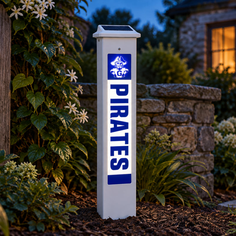 Galena Pirates Solar Glow Post lit up at dusk beside a stone garden wall.