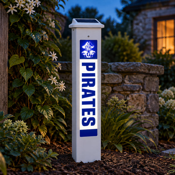 Galena Pirates Solar Glow Post lit up at dusk beside a stone garden wall.