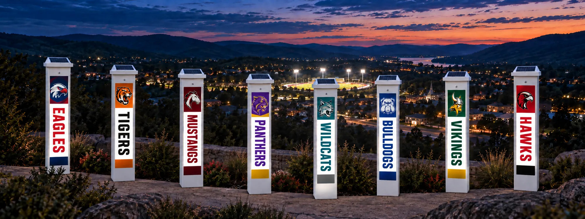 Eight FanPillar Solar Glow Posts in different school colors glowing above a town at dusk